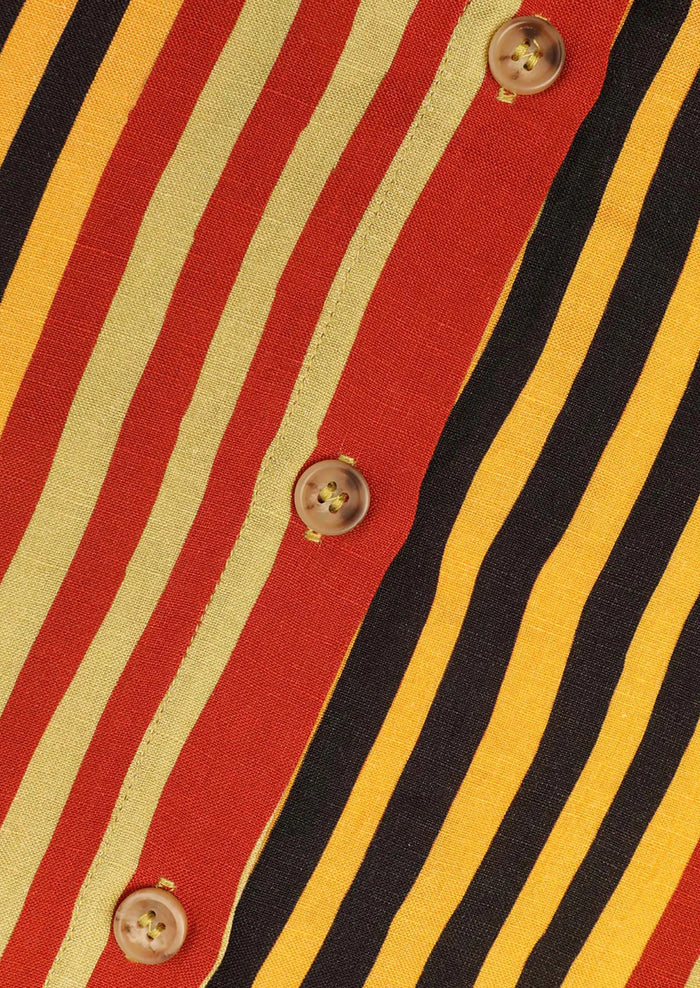 Close-up of a shirt with red, yellow, and black striped pattern and button details.