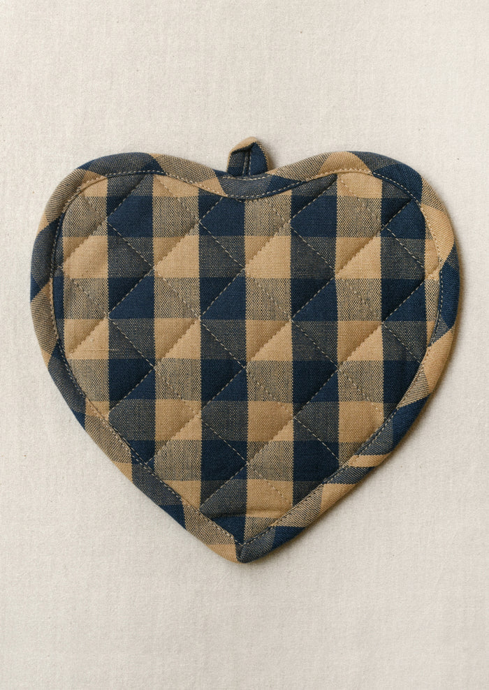 A heart shaped pot holder with a navy and tan gingham pattern.