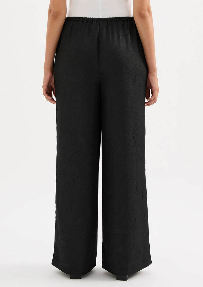 Black wide-leg pants worn by a person on a white background