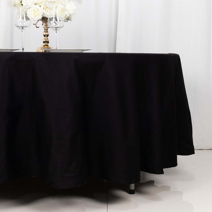 Black tablecloth draped elegantly over a round table with floral centerpiece.