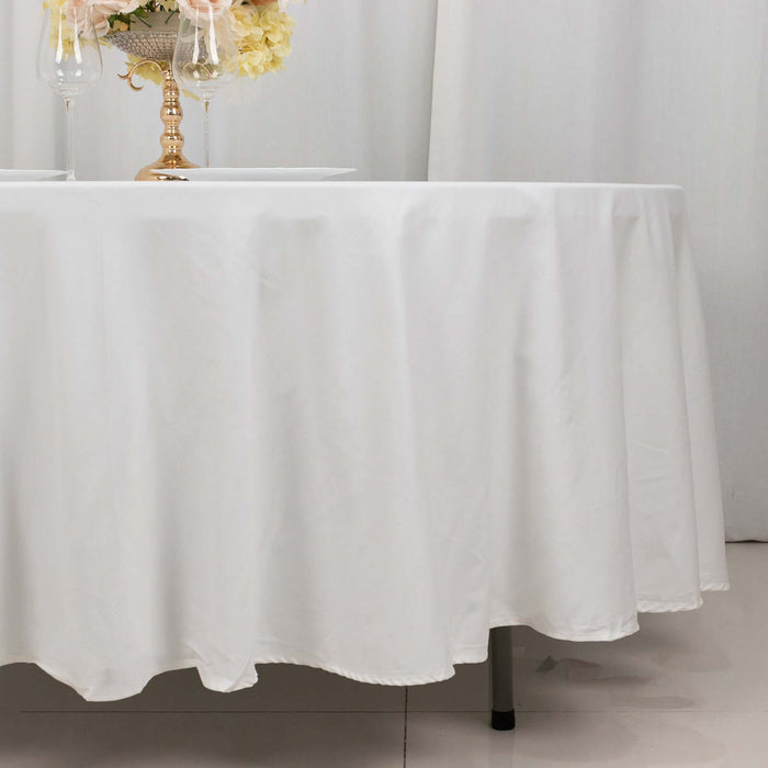 White tablecloth elegantly draping over a round table with decorative elements.