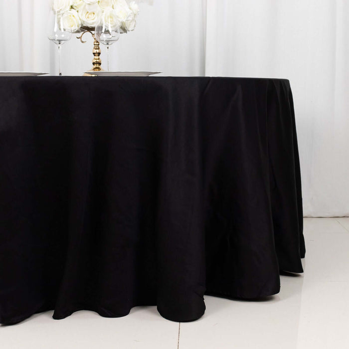 Black tablecloth draped elegantly on a round table in a formal setting.