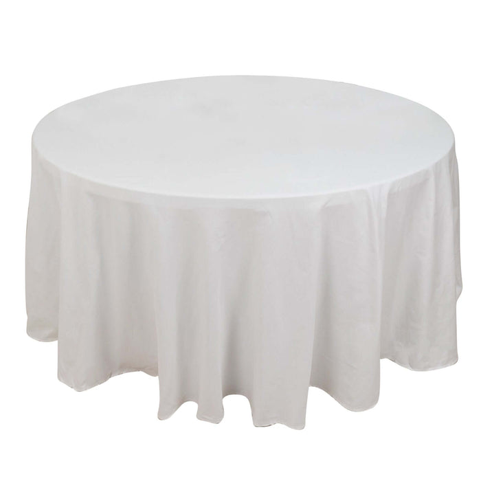 Round table with a white tablecloth on a plain background