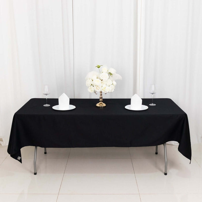 Elegant black table setup with white floral centerpiece and table settings.