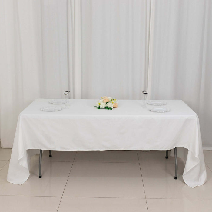 White table set for dining with floral centerpiece and tableware.