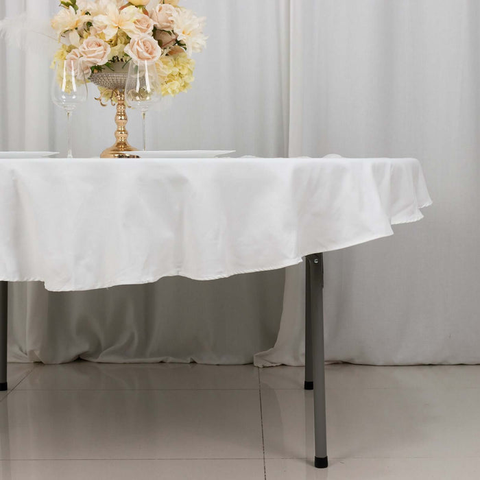 Elegant table setting with white tablecloth and floral centerpiece.