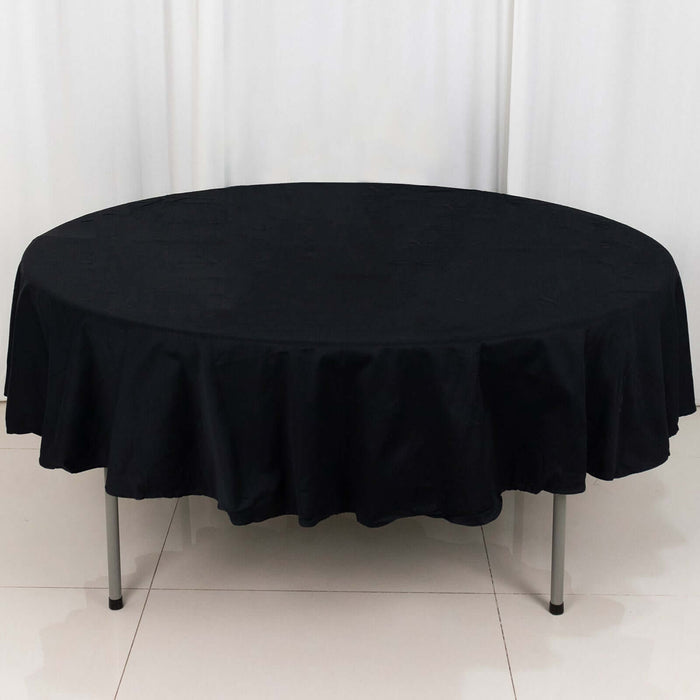 Round black tablecloth with ruffled edges, perfect for elegant dining settings.