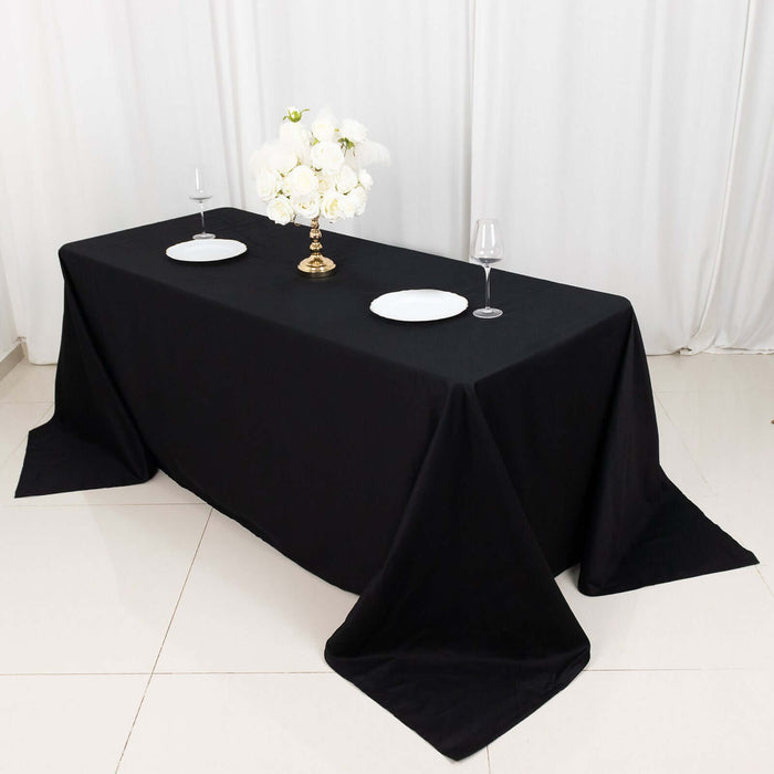 Elegant black tablecloth draped over a table set for dining with floral centerpiece.