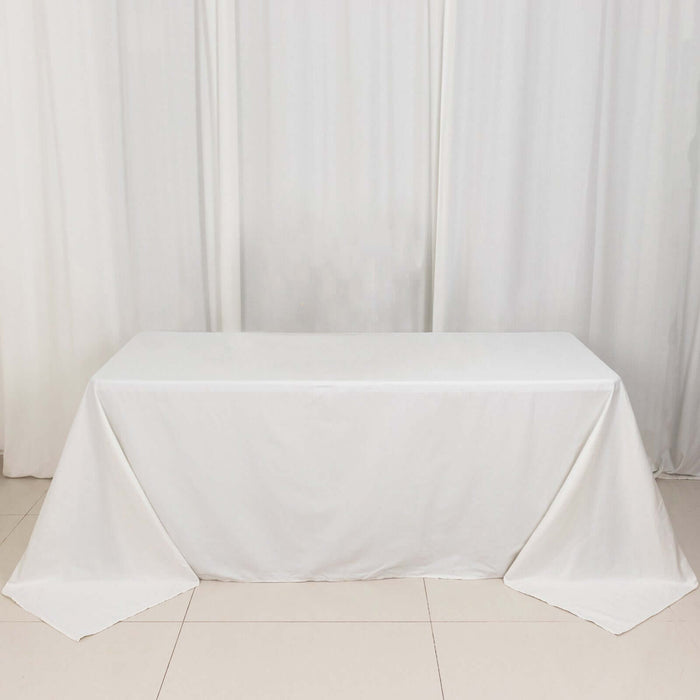 White tablecloth draped on a table against a plain backdrop.