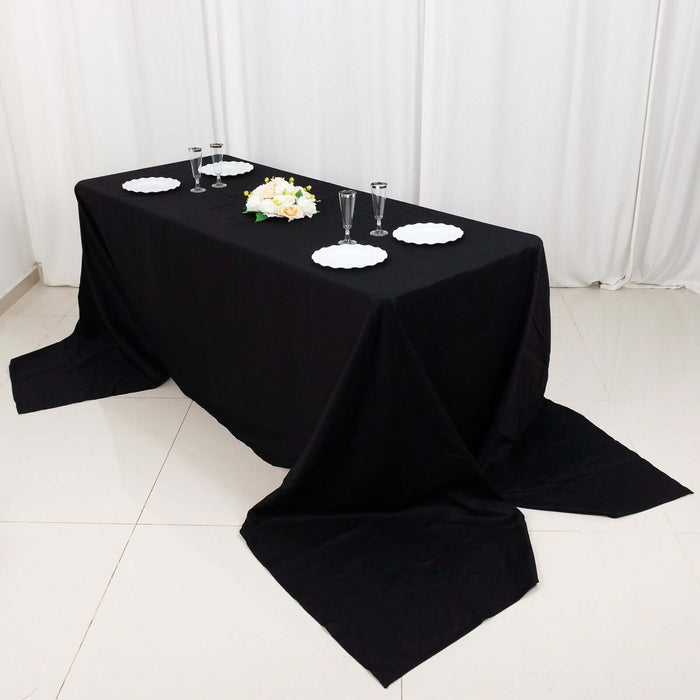 Black table set for an elegant dining experience with plates and glasses.