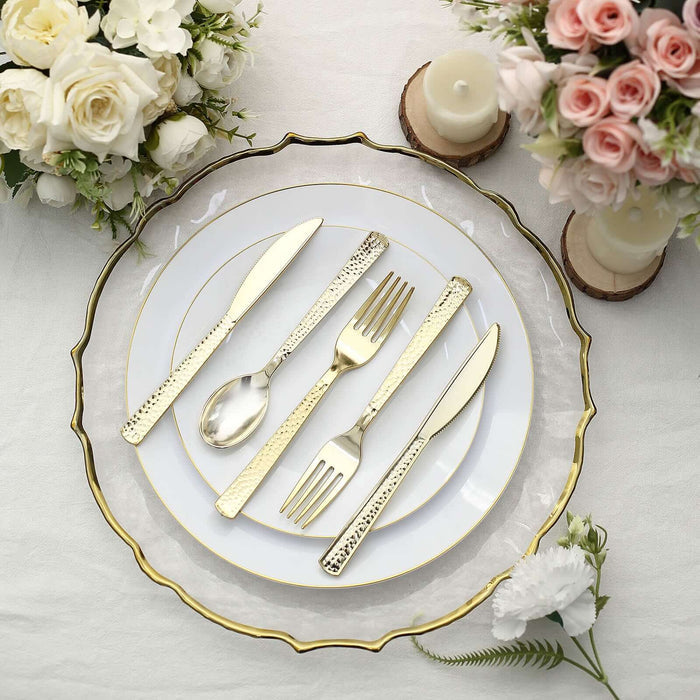 Elegant gold cutlery set on a decorative plate with floral arrangements.