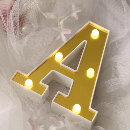 Illuminated yellow letter A with white border on soft tulle background.