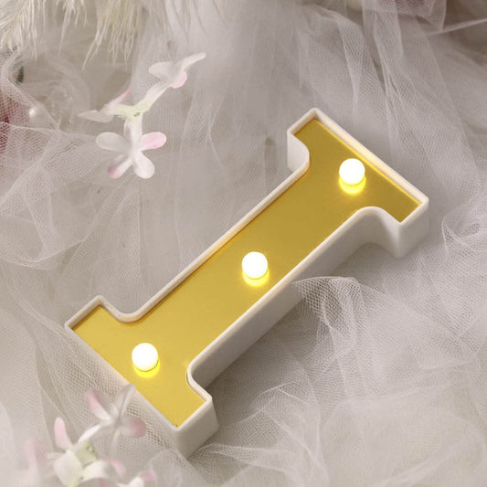 Yellow letter "I" light-up decor on soft, textured background.