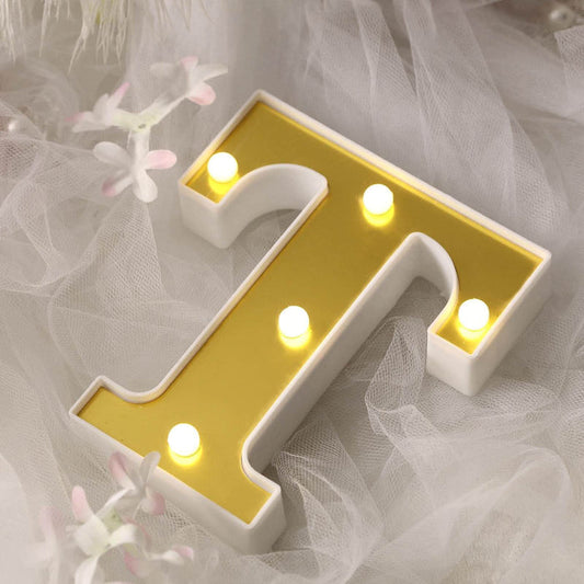 Illuminated letter "T" decor with a gold background and white outer edge.
