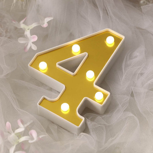 Yellow light-up number 4 decoration on soft fabric background.