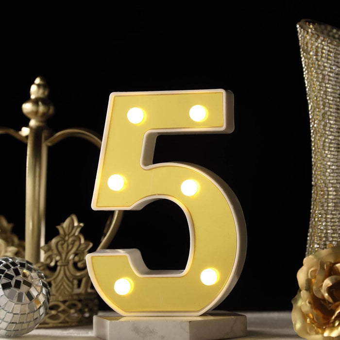 Illuminated yellow number 5 decoration with lights on a dark backdrop. #whtbkgd