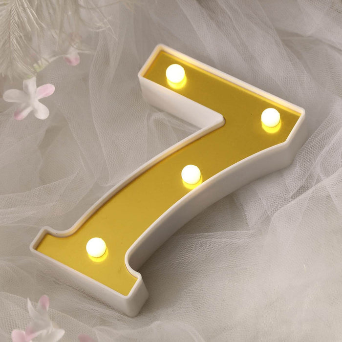 Yellow number 7 light-up sign with bulbs on a soft backdrop.