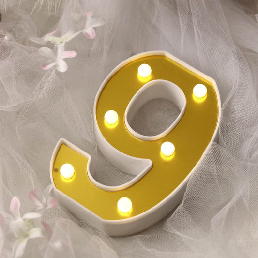 Illuminated yellow number 9 decoration with lights.