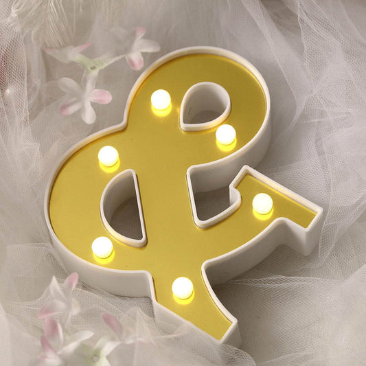 Yellow ampersand light decor with bulbs on a soft backdrop.