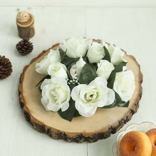 White artificial rose arrangement on a wooden slice with decorative elements.
