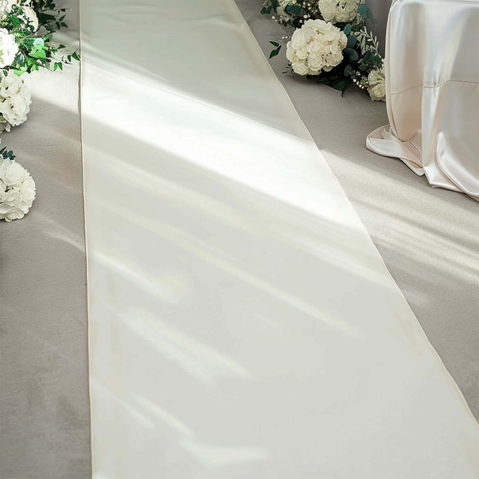 Elegant cream satin aisle runner surrounded by floral decor.