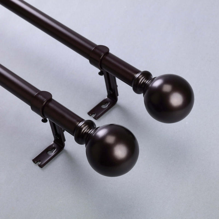 Bronze curtain rods with decorative finials, showcasing elegant design.