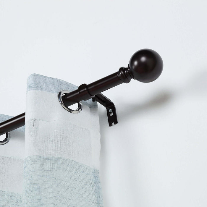 Curtain rod with decorative finial and grommet-style curtains