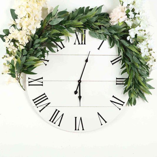 Floral wall clock with Roman numerals and greenery accents.