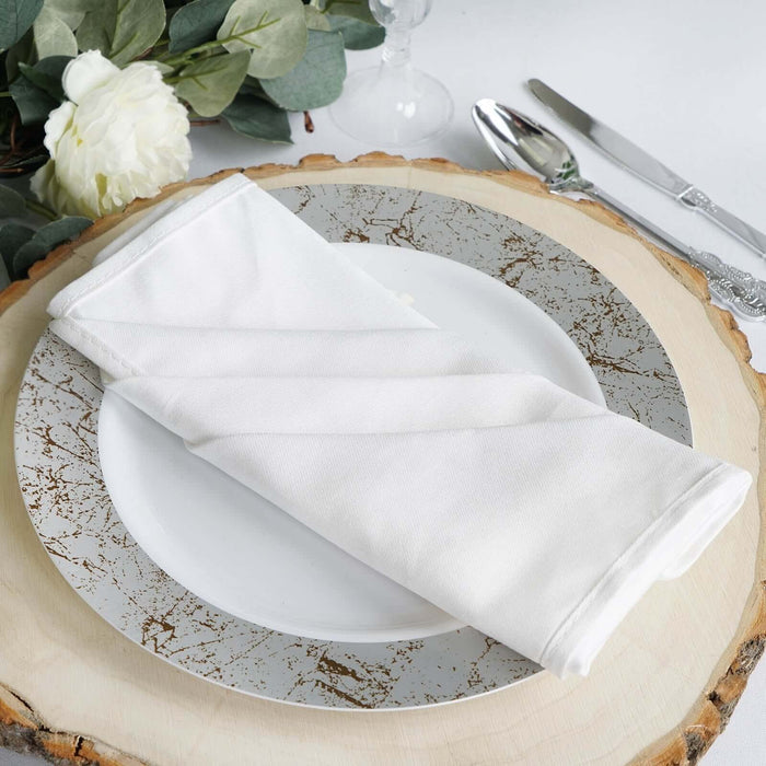 White napkin elegantly folded on a decorative plate with a rustic wood charger.