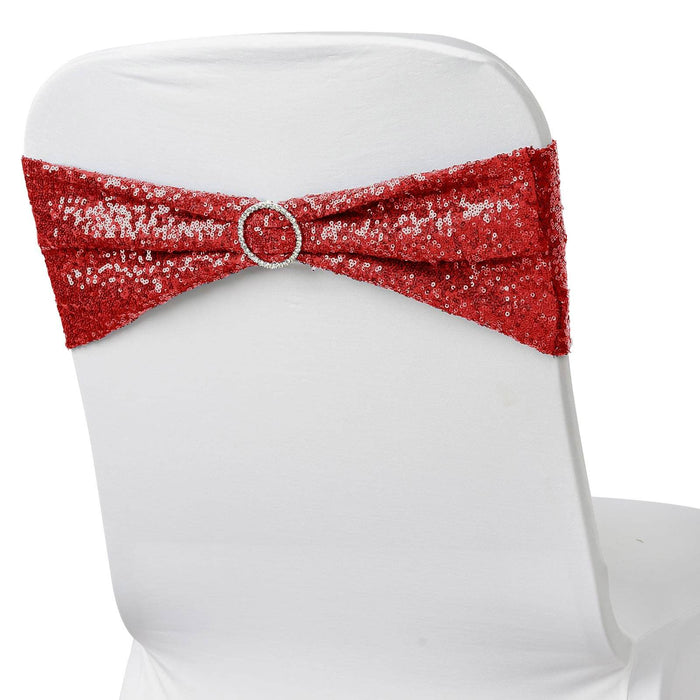 Red sequin chair cover with a decorative bow and rhinestone buckle.