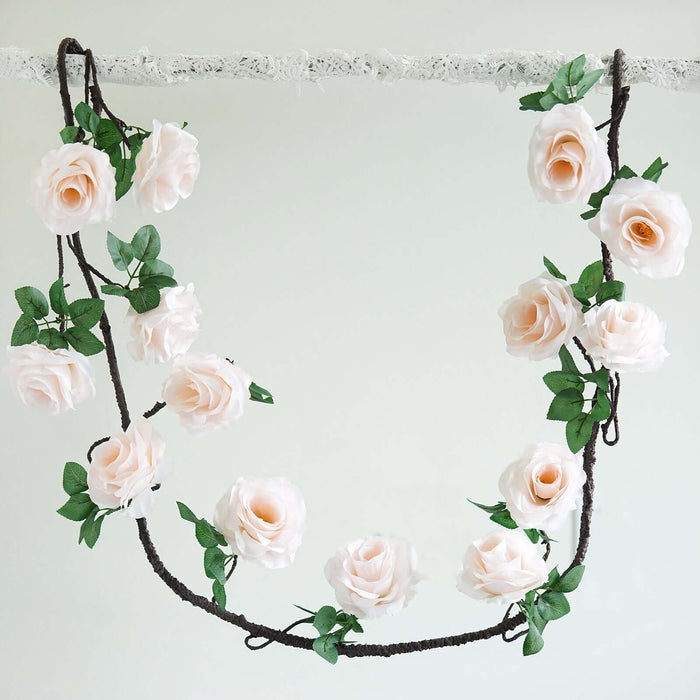 Artificial pink rose garland with green leaves on a white backdrop