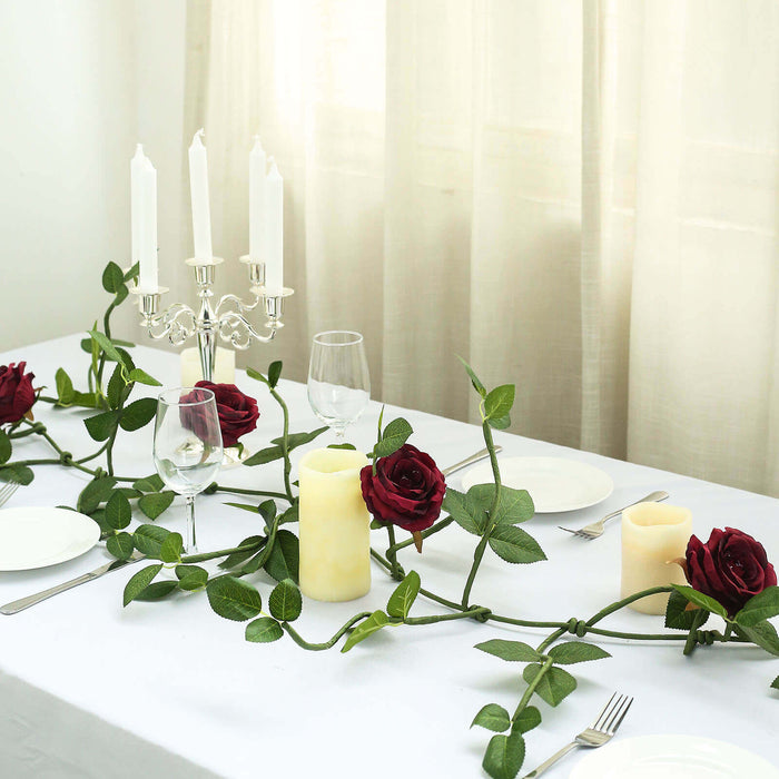 Elegant table setting with roses, candles, and glassware for a romantic dinner.