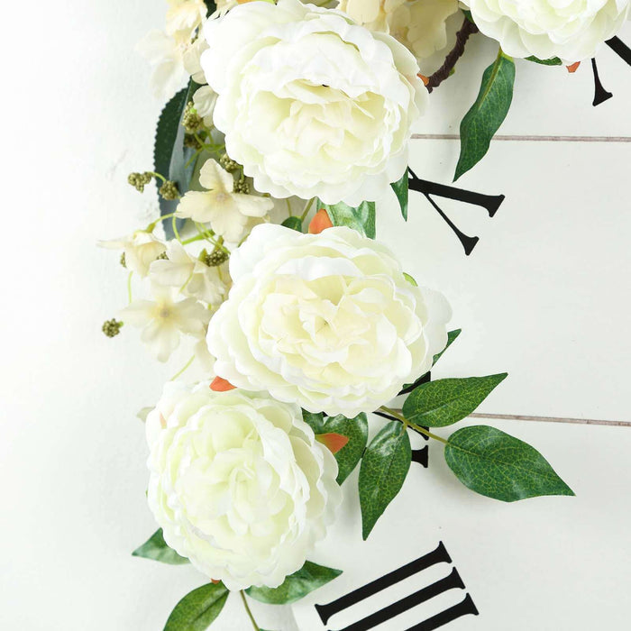 Artificial white flowers with greenery on a decorative clock backdrop.