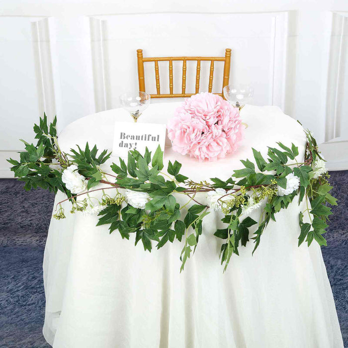 Floral centerpiece with pink peony and greenery on a table setting.