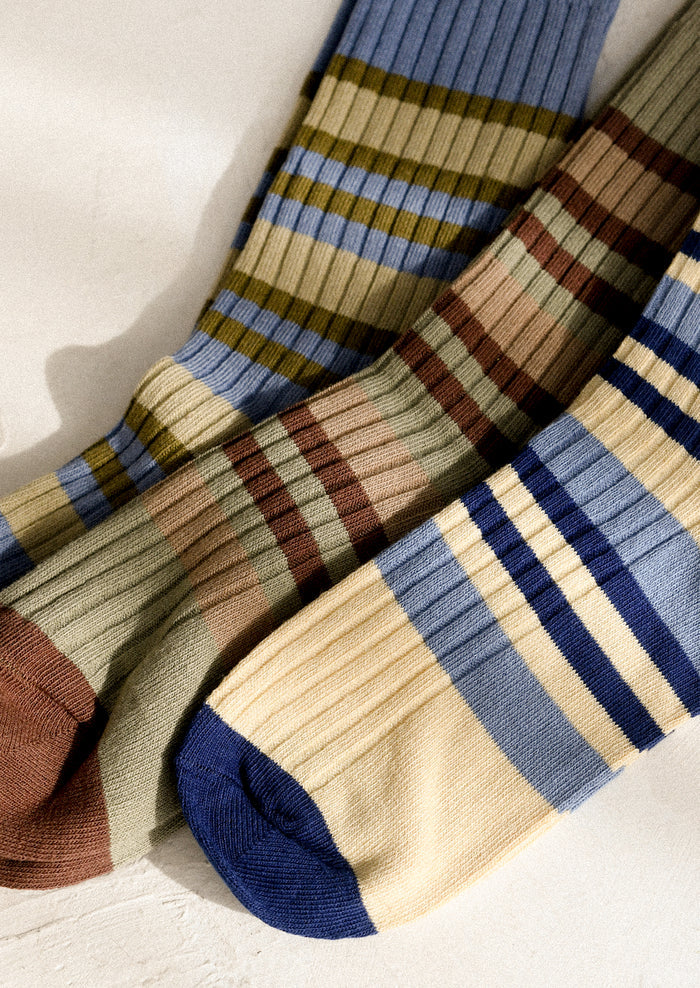 Pair of striped socks with blue, brown, and beige colors on a light background