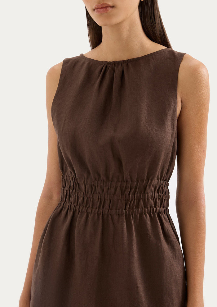 Brown sleeveless dress worn by a model on a white background