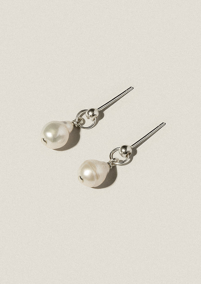 Pair of pearl earrings on a light gray background