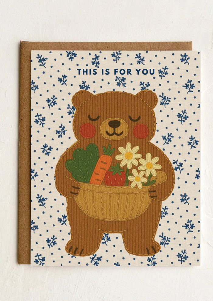Card with a bear holding flowers and vegetables on a patterned background
