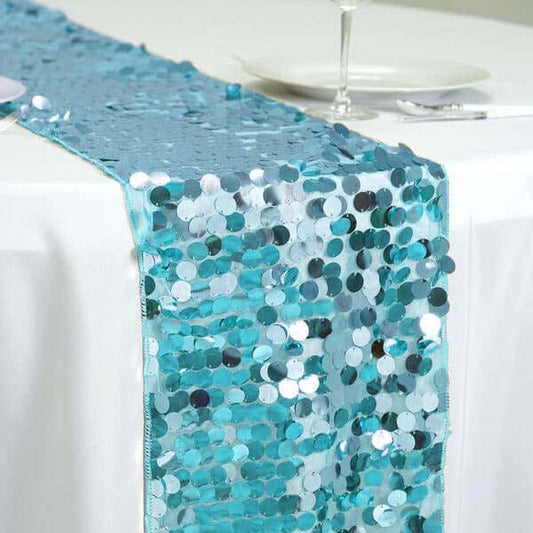 Turquoise sequin table runner on a white tablecloth