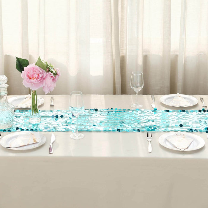 Table setting with aqua sequin runner, flowers, and elegant dinnerware.
