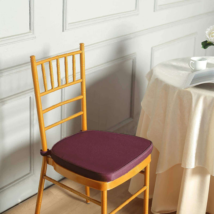 Chair cushion in deep purple on a wooden chair near a table.