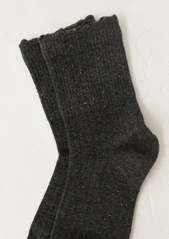 Pair of dark gray socks with speckled pattern on a light background