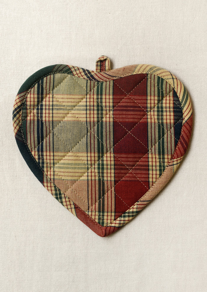A heart shaped pot holder in multicolor plaid pattern.