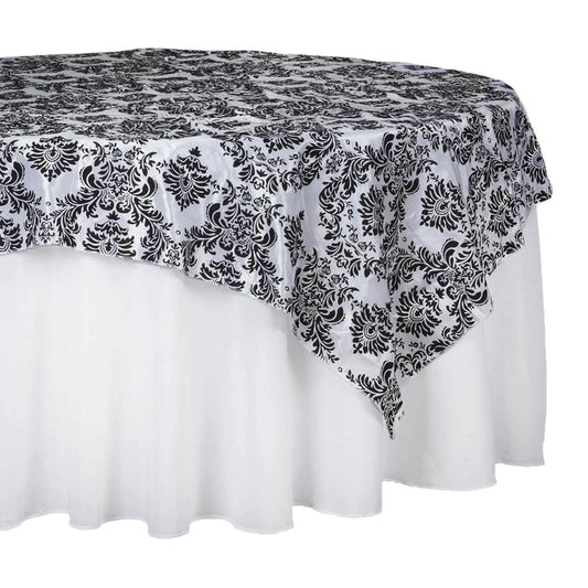 Black and white damask tablecloth draped over a round table.