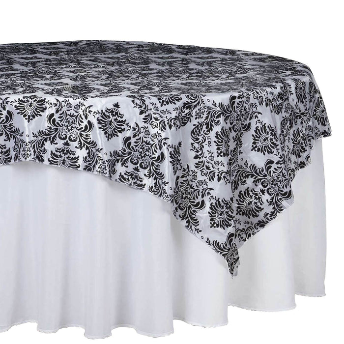 Black and white damask tablecloth draped over a round table