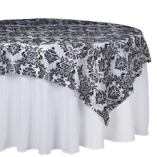 Black and white damask tablecloth draped over a round table