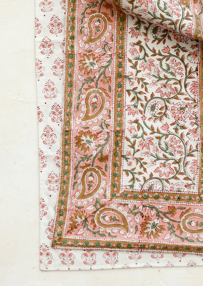 Close-up of a floral and paisley patterned fabric on a white background