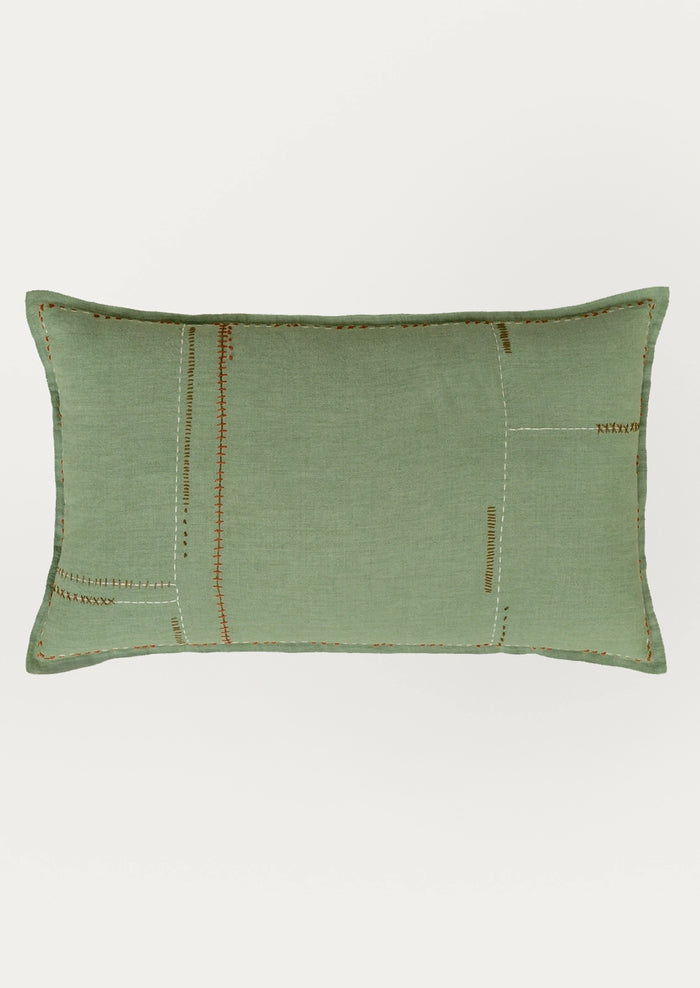 A rectangular sage green lumbar pillow with a linen-like textured fabric and decorative patchwork-style stitching in contrasting orange-brown and cream thread, shown against a plain light gray background.