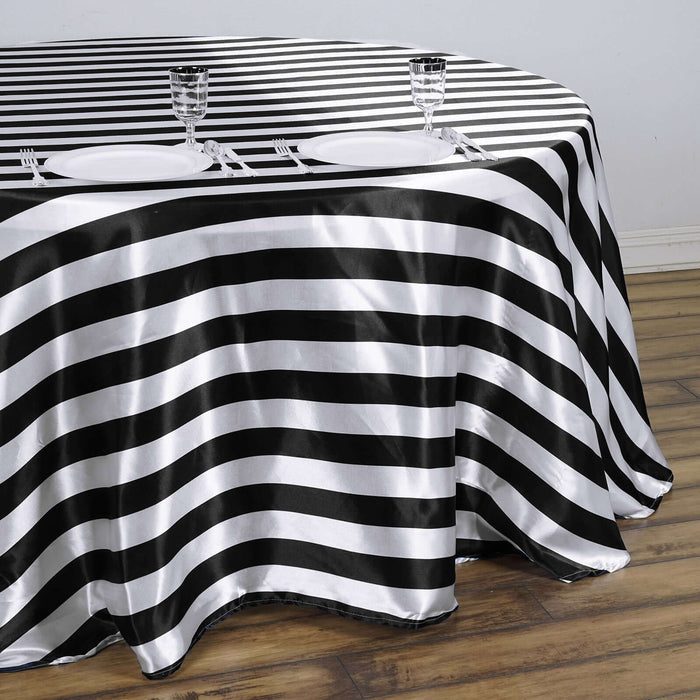 Black and white striped tablecloth on a wooden floor with dining setup.