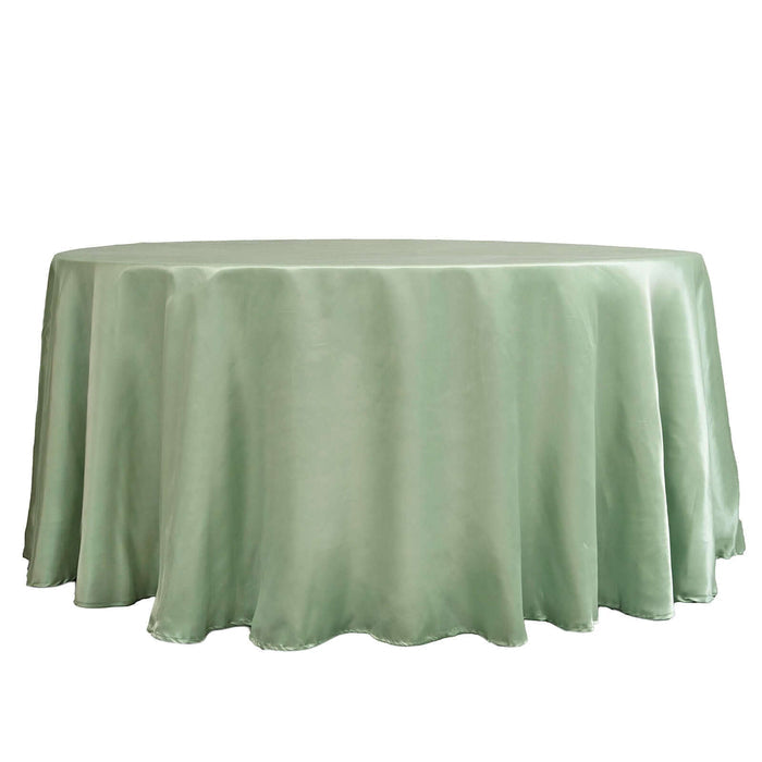 Round green satin tablecloth on a plain backdrop.